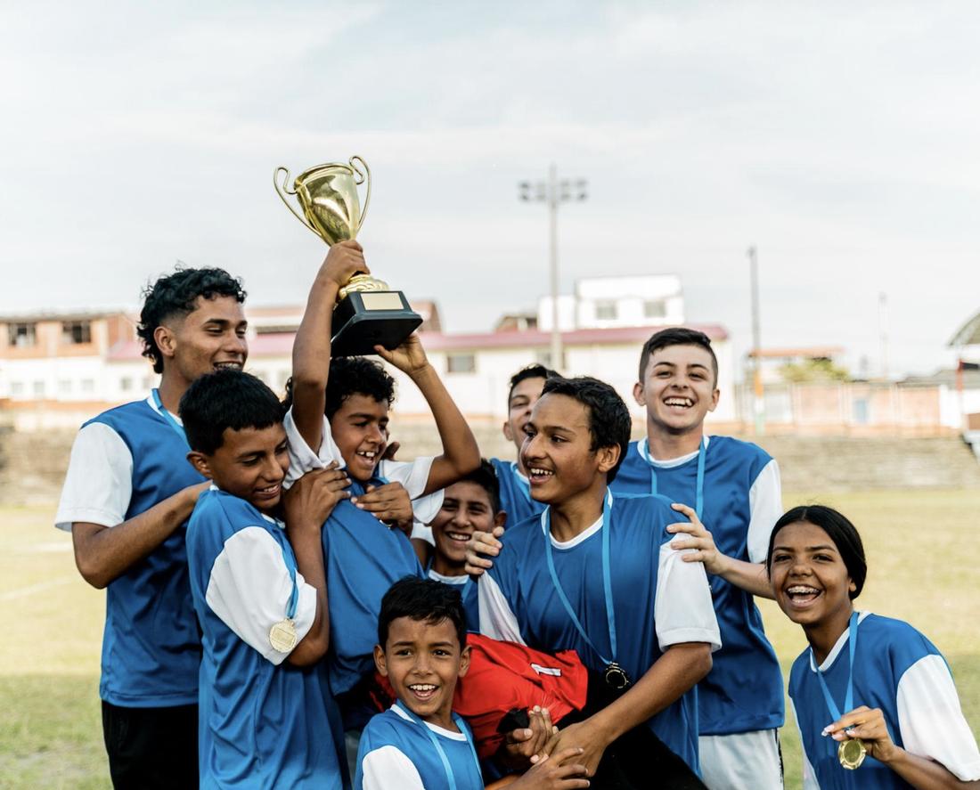 Un equipo festeja levantando la copa después de ganar.